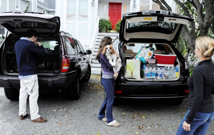 The Flaven family pack up their cars before evacuating the area in Fairfield, Conn., Sunday, Oct. 28, 2012. Mandatory evacuations have been ordered for Sunday in parts of Bridgeport, Fairfield, East Haven, Old Lyme, Old Saybrook and Branford. Voluntary evacuations are being urged in parts of Westport and New London. (AP Photo/Jessica Hill)