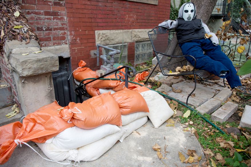 A stuffed "Jason" replica from the Friday the 13th movies sits on a bench next to a stack of sandbags that line the stairway to a basement apartment in the Bloomingdale neighborhood off of Rhode Island Avenue in Washington, D.C. on Sunday, Oct. 28, 2012. D.C. residents in this neighborhood are particularly concerned about flooding issues from Sandy, the so-called "Frankenstorm," which is expected to hit the area sometime tonight. (Barbara L. Salisbury/The Washington Times)
