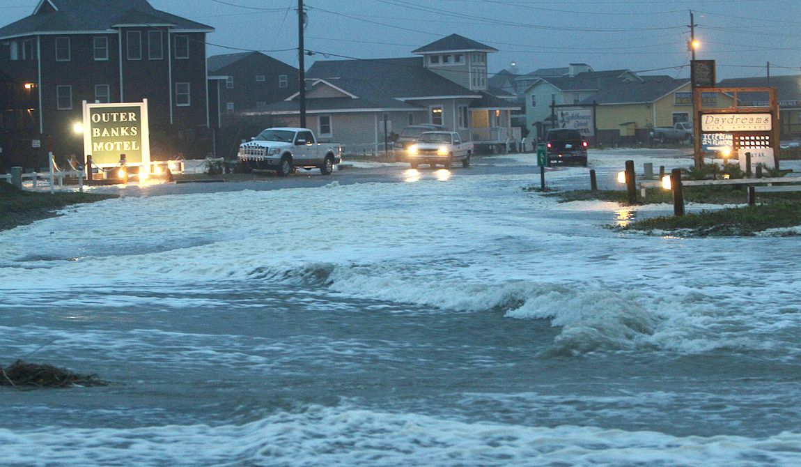 Ocean water rolls over Route 12 at the north end of Buxton, N.C., at dawn on Sunday, Oct. 28, 2012, as waves from Hurricane Sandy battered Hatteras Island. (AP Photo/The Virginian-Pilot, Steve Earley)