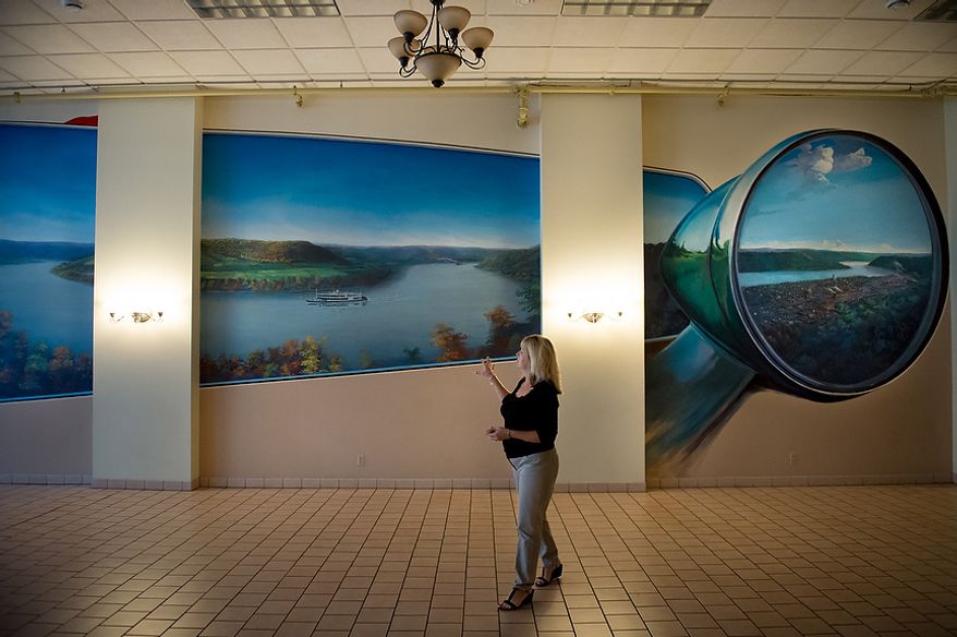 Debi Froehlich looks at a large mural of the untouched original landscape of the town of Steubenville, Ohio, Friday, October 26, 2012. Debi, who owns Froehlich Classic Corner restaurant with her husband Greg, also owns the much larger building the restaurant occupies which was at one point the electric company for the town. This room used to be a Jaguar automobile museum and is now used as space for parties and weddings. Once a productive steel town, Steubenville, Ohio's population has contracted faster than anywhere else in the country between 1980 and 2000 as their steel plants shut down. The area has seen a drop in unemployment in recent years due in part to the prospects of natural gas but the city still has a long way to go with unemployment figures higher then the the rest of the state and the country. (Andrew Harnik/The Washington Times)