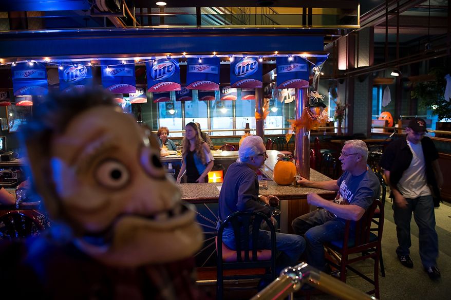 Steve Gagliardi of Steubenville, Ohio, second from right, and Paul Grant, third from right, talk together at the bar at Froehlich's Classic Corner restaurant, Steubenville, Ohio, Friday, October 26, 2012. Of the election Gagliardi says, "I'm a Romney supporter. I've been a banker all of my life and the debt of this nation will cripple us." Once a productive steel town, Steubenville, Ohio's population has contracted faster than anywhere else in the country between 1980 and 2000 as their steel plants shut down. The area has seen a drop in unemployment in recent years due in part to the prospects of natural gas but the city still has a long way to go with unemployment figures higher then the the rest of the state and the country. (Andrew Harnik/The Washington Times)