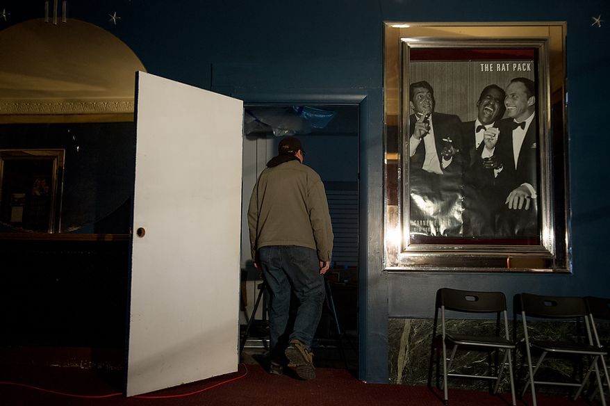 Scott Dressel who has put most of his retirement savings into buying and restoring homes in Steubenville, Ohio, walks past an old poster of Dean Martin, who's hometown was Steubenville, along with Sammy Davis Jr. and Frank Sinatra, in the front lobby of the old Grand Theatre with citizens have partnered together to buy and renovate to help spur economic development, Steubenville, Ohio, Saturday, October 27, 2012. Once a productive steel town, Steubenville, Ohio's population has contracted faster than anywhere else in the country between 1980 and 2000 as their steel plants shut down. The area has seen a drop in unemployment in recent years due in part to the prospects of natural gas but the city still has a long way to go with unemployment figures higher then the the rest of the state and the country. (Andrew Harnik/The Washington Times)