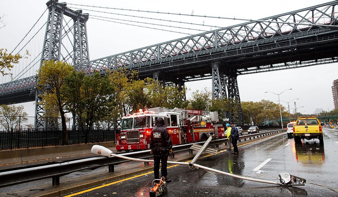 Police and firefighters respond to a downed street light on FDR Drive on Monday, Oct. 29, 2012, in New York. Hurricane Sandy continued on its path Monday, forcing the shutdown of mass transit, schools and financial markets; sending coastal residents fleeing; and threatening a dangerous mix of high winds and soaking rain. (AP Photo/John Minchillo)