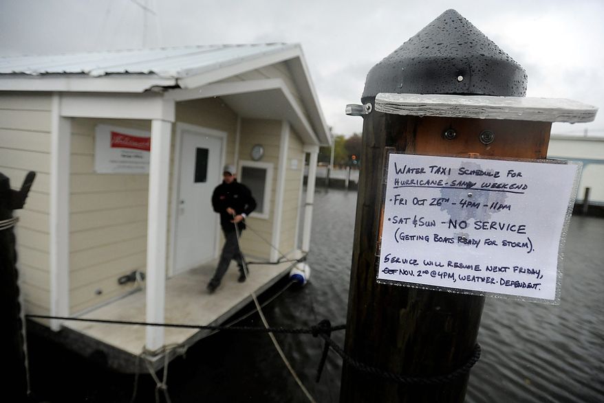 Brandon White of Watermark, a tour and charter boat company, ties one of the company's boats to a pier in Annapolis as Hurricane Sandy approaches the East Coast on Monday, Oct. 29, 2012. Hurricane Sandy continued on its path Monday, forcing the shutdown of mass transit, schools and financial markets; sending coastal residents fleeing; and threatening a dangerous mix of high winds and soaking rain. (AP Photo/Steve Ruark)
