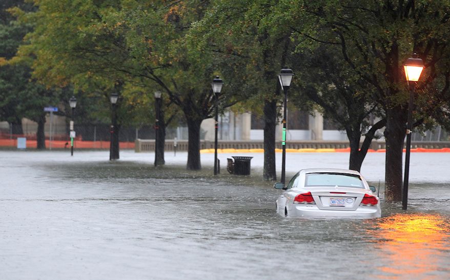 A stranded car sits along a street near downtown Norfolk, Va., on Monday, Oct. 29, 2012. Rain and wind from Hurricane Sandy were hitting the area. (AP Photo/Steve Helber)