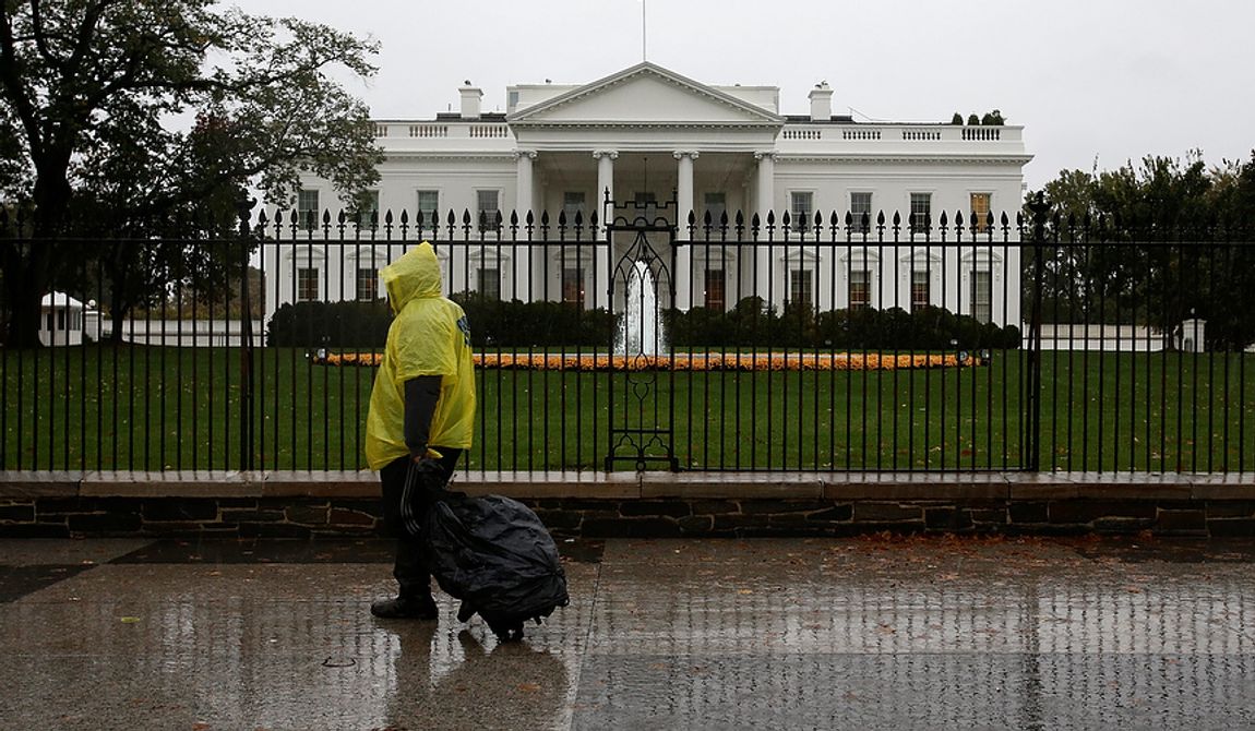 A lone man wearing a rain poncho walks past the White House in Washington on Monday, Oct. 29, 2012, during the approach of Hurricane Sandy. (AP Photo/Jacquelyn Martin)