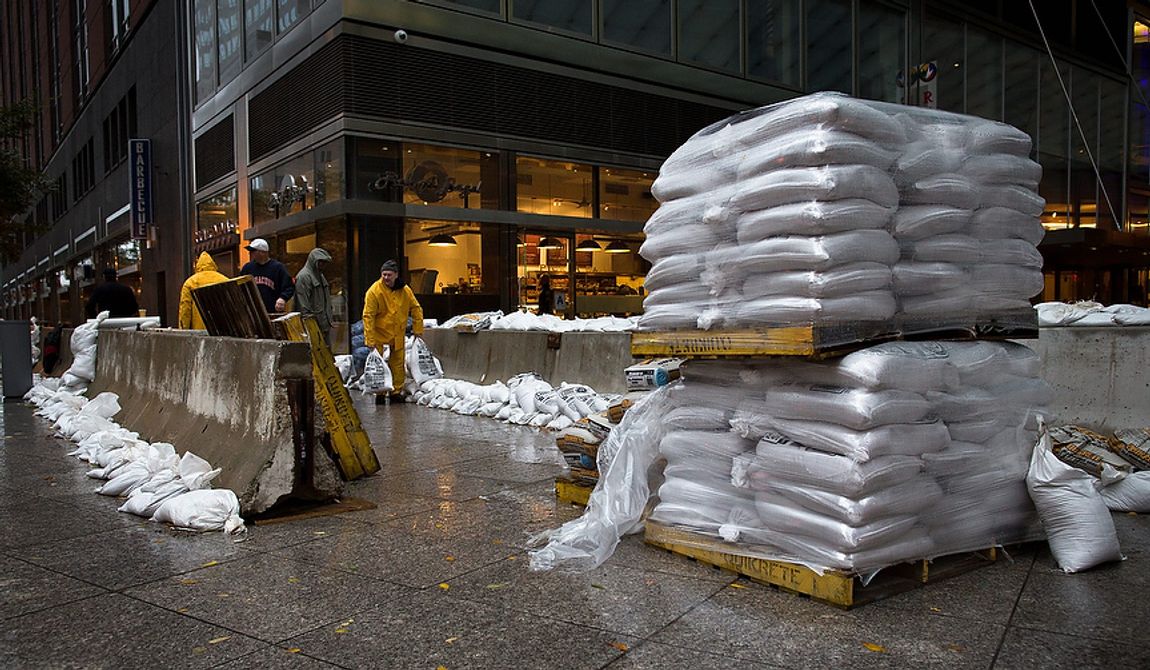 Workers stack sandbags beside concrete barriers to protect buildings near the World Financial Center in anticipation of flooding on Monday, Oct. 29, 2012, in New York. Hurricane Sandy bore down on the Eastern Seaboard&#x27;s largest cities Monday, forcing the shutdown of mass transit, schools and financial markets; sending coastal residents fleeing; and threatening a dangerous mix of high winds, soaking rain and a seawater surge of anywhere from 6 to 11 feet. (AP Photo/ John Minchillo)