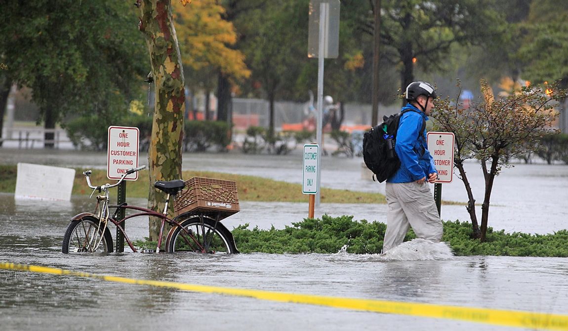 A Norfolk, Va., resident chains his bike and heads to work in floodwaters near downtown on Monday, Oct. 29, 2012. Rain and wind from Hurricane Sandy were hitting the area. (AP Photo/Steve Helber)