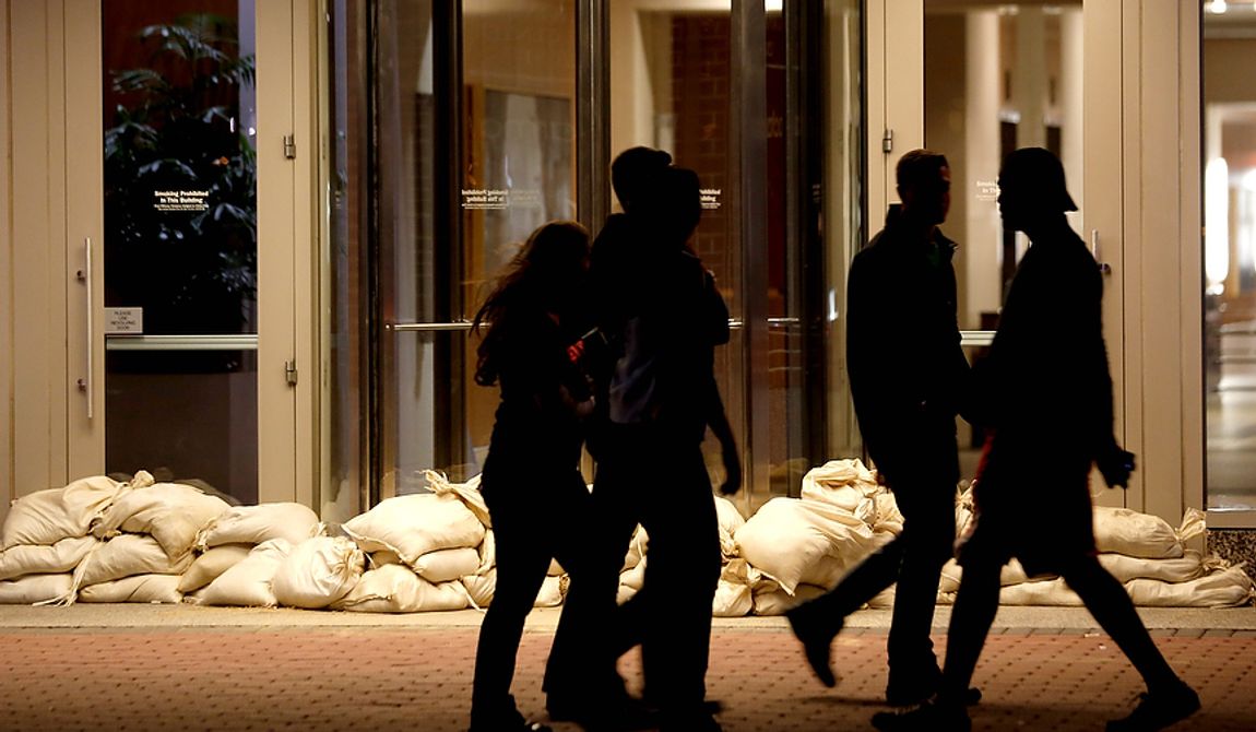 Sandbags line the entrance of a building as people walk by near the Hudson River waterfront on Sunday, Oct. 28, 2012, in Hoboken, N.J. Tens of thousands of people were ordered to evacuate coastal areas Sunday as big cities and small towns across the Northeast braced for the onslaught of a superstorm threatening some 60 million people along the most heavily populated corridor in the nation. (AP Photo/Julio Cortez)