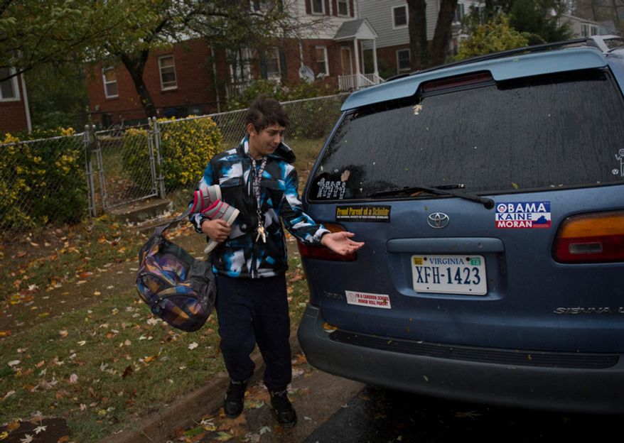 A young man removes belongings from a home on Arlington Terrace in the Huntington neighborhood of Alexandria, Va., on Oct. 29, 2012, during a mandatory evacuation order as high winds and heavy rain from Hurricane Sandy pound the Atlantic coast. (Rod Lamkey Jr./The Washington Times)