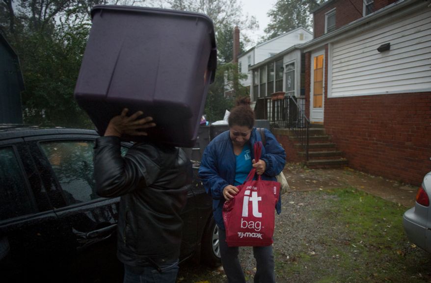 Rosa Merino and her family leave from their home on Arlington Terrace in the Huntington neighborhood of Alexandria, Va., on Oct. 29, 2012, during a mandatory evacuation order as high winds and heavy rain from Hurricane Sandy pound the Atlantic coast. (Rod Lamkey Jr./The Washington Times)