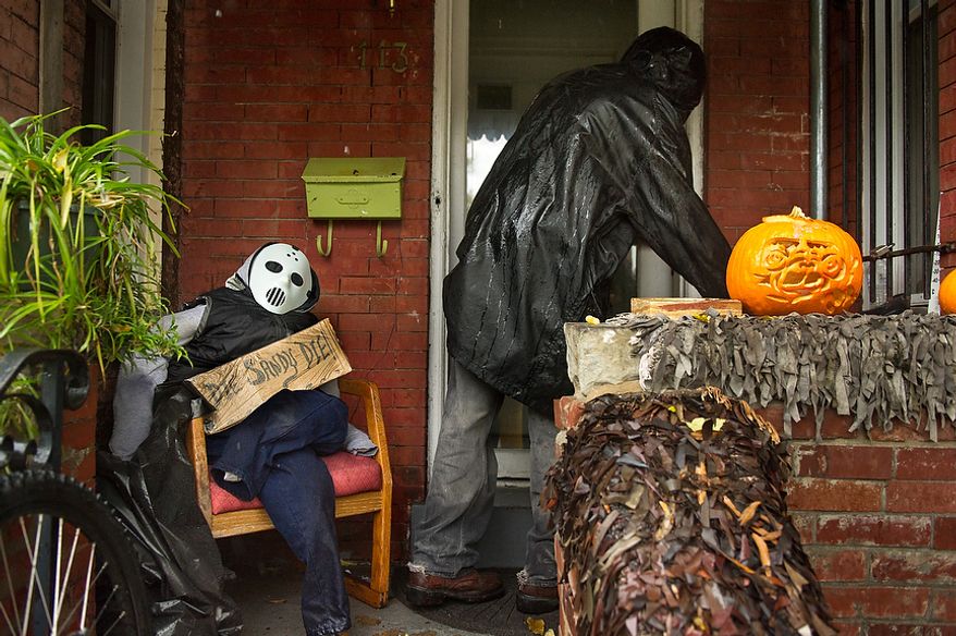 Clyde Forbes walks into the front of his house past a halloween pumkin and maniquen with a sign that reads "Die Sandy Die!" along a section of Rhode Island Avenue that has been prone to flooding from big storms in the Bloomingdale neighborhood of Northwest, Washington, D.C., Monday, October 29, 2012. Hurricane Sandy begins to affect the Washington, D.C. region. (Andrew Harnik/The Washington Times)