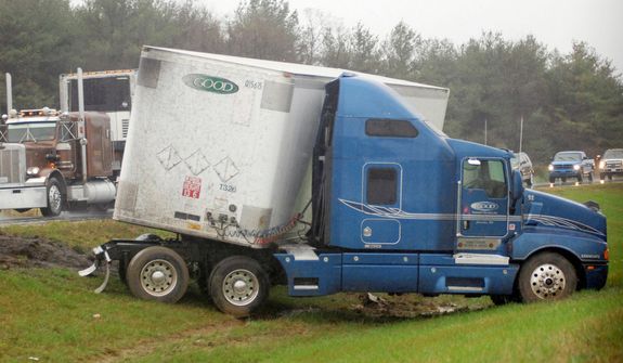 An 18-wheel tractor trailer belonging to the Extra Good Transport Services, Inc. based in Columbia, Pa., sits on a median strip after jacknifing along I-81 about 1/4 mile north of the West Virginia/Virginia border near Ridgeway, W.Va. on Monday, Oct 29, 2012. (AP Photo/The Journal, Ron Agnir)