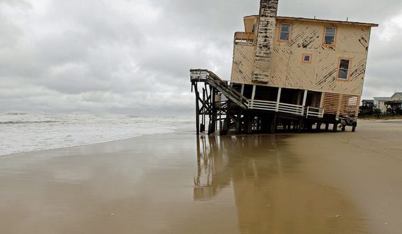 An abandoned beach house that survived the storm surge from Hurricane Sandy sits off center in Nags Head, N.C., Monday, Oct. 29, 2012. The storm continued on its path Monday, forcing  the shutdown of mass transit, schools and financial markets,  and sending coastal residents fleeing. (AP Photo/Gerry Broome)