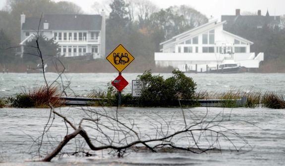 A downed limb lies in a flooded street as Hurricane Sandy approaches, Monday, Oct. 29, 2012, in Center Moriches, N.Y.  (AP Photo/Jason DeCrow)