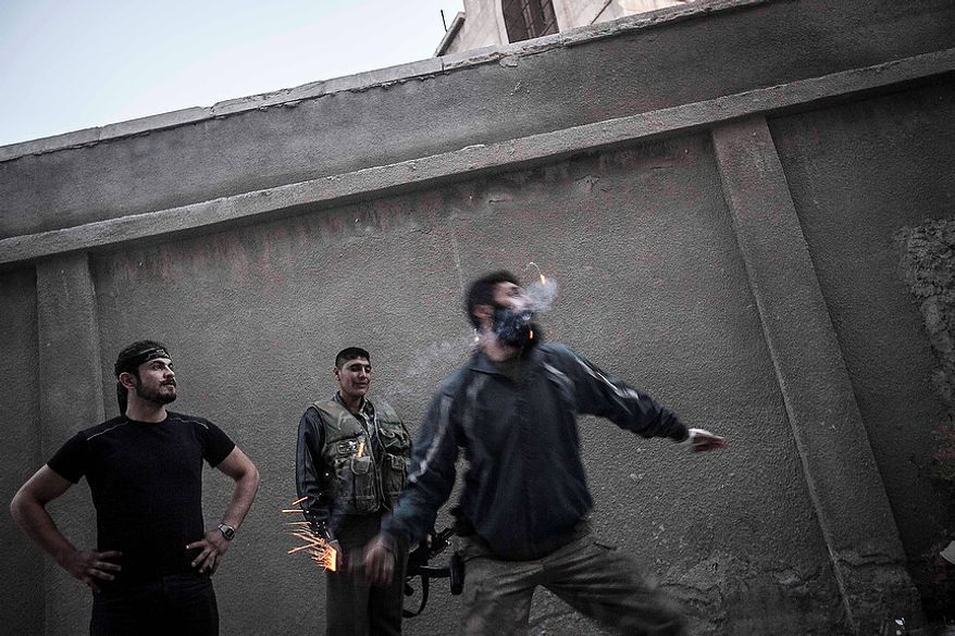 A rebel fighter throws a homemade grenade toward Syrian army troops on the front line in the Bustan Al-Pasha neighborhood of Aleppo, Syria, on Sunday, Oct. 28, 2012. Syria's air force fired missiles and dropped barrel bombs on rebel strongholds while opposition fighters attacked regime positions, flouting a U.N.-backed cease-fire that was supposed to quiet fighting over a long holiday weekend but never took hold. (AP Photo/Narciso Contreras)
