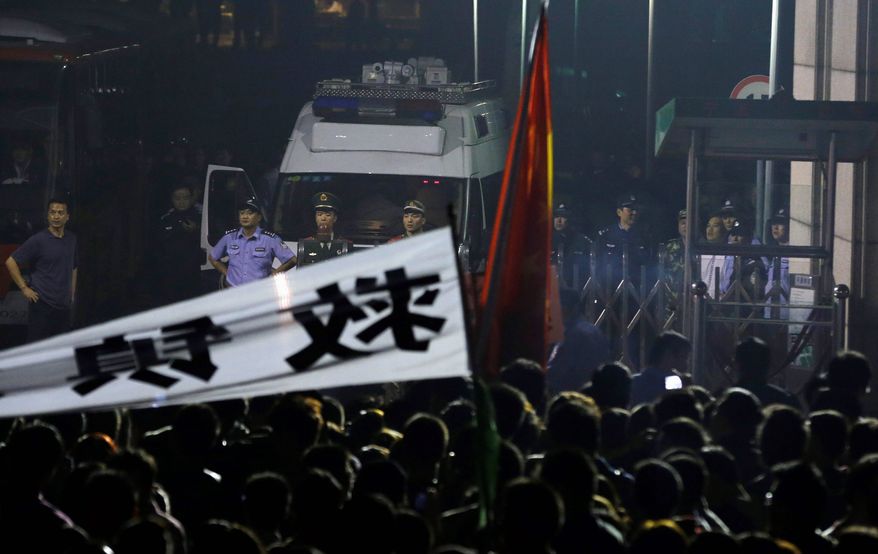 Chinese security guards the entrance to the Ningbo city government office where residents gathered Sunday to protest the expansion of a petrochemical factory. The local government relented and agreed not to expand the factory. (Associated Press)
