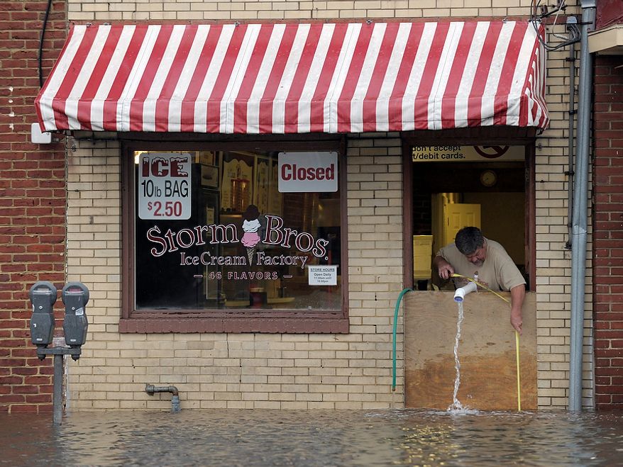 Sveinn Storm, owner of Storm Bros. Ice Cream Factory measures the flood waters outside his store in Annapolis, Md., Tuesday, Oct. 30, 2012, in the aftermath of Superstorm Sandy that passed through the East Coast. (AP Photo/Susan Walsh)