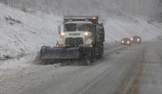 Snowplows thunder through the mountains of West Virginia as the superstorm strikes the region on Monday evening, Oct. 29, 2012. In the higher elevations of the mountains, there could be from 2 to 3 feet of snow and blizzard conditions through Tuesday. (AP Photo/Robert Ray)
