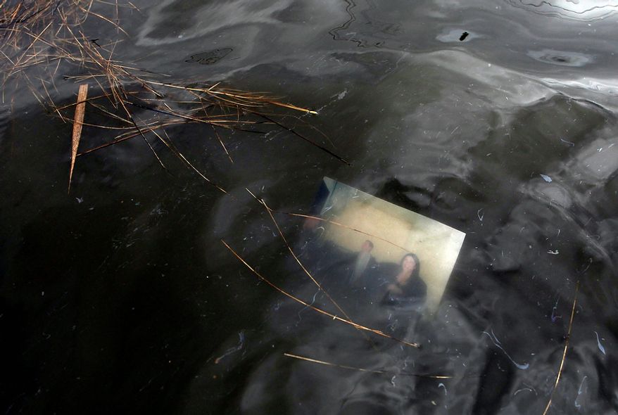 A photograph floats just below the surface of a flooded street in the aftermath of superstorm Sandy, Tuesday, Oct. 30, 2012, in Massapequa, N.Y. (AP Photo/Jason DeCrow)