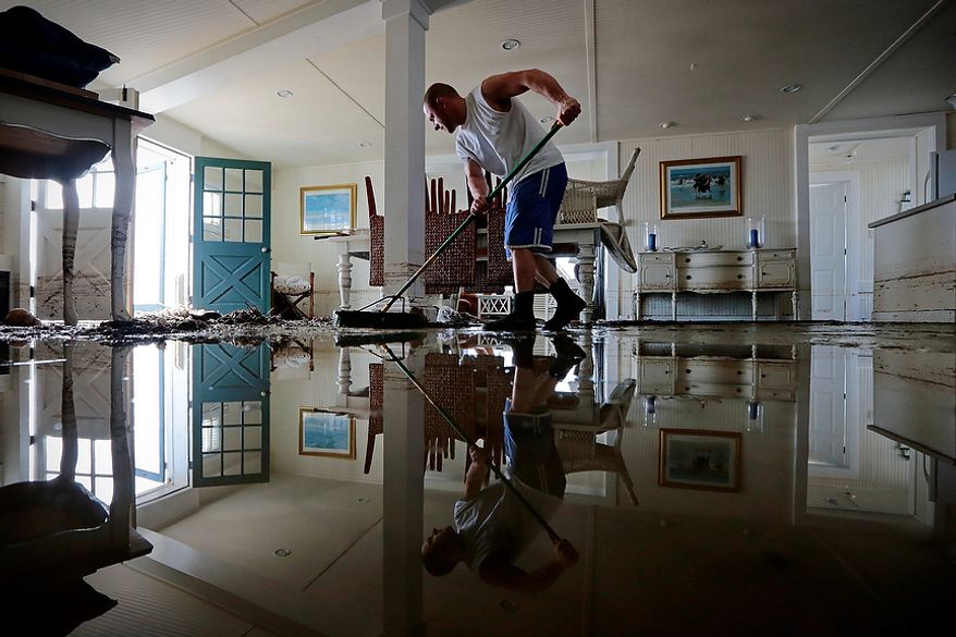 Jason Locke sweeps water and mud from his parents' home in Westport, Mass., Tuesday, Oct. 30, 2012. Many homeowners who suffered losses because of flooding from Hurricane Sandy are likely to find themselves out of luck. Standard homeowners policies don't cover flooding damage, and the vast majority of homeowners don't have flood insurance.Yet it's likely that many Northeasterners will purchase it in coming months, hoping they'll be covered the next time around, at a cost averaging around $600 a year. (AP Photo/The Standard Times, Peter Pereira)