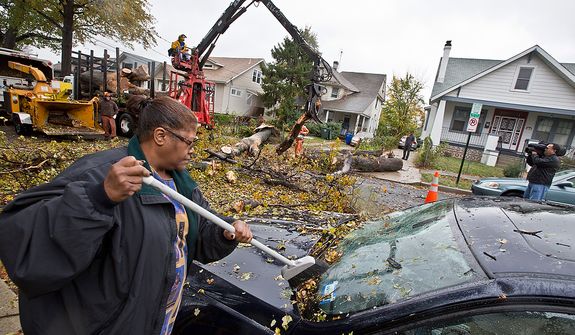 A resident on the 1100 block of Evarts St. NE removes debris left by a downed tree caused by hurricane Sandy, in Washington, D.C., Tuesday, October 30, 2012. The effects of hurricane Sandy have impacted many in the DC area.  (Andrew S. Geraci/The Washington Times)