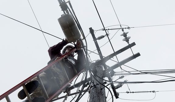 Cable TV worker Fred Harris does maintenance on lines in this 2012 photo. (Barbara L. Salisbury/The Washington Times)