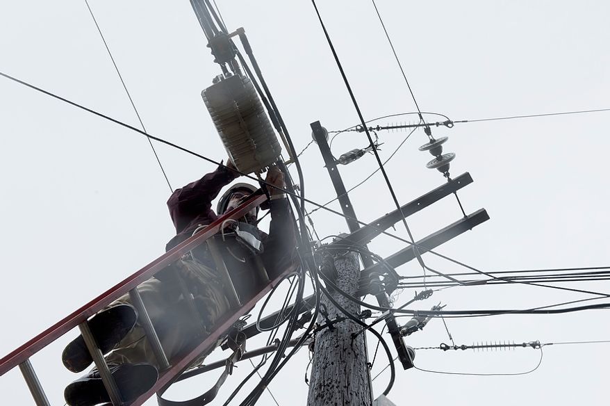Cable TV worker Fred Harris does maintenance on lines in this 2012 photo. (Barbara L. Salisbury/The Washington Times)