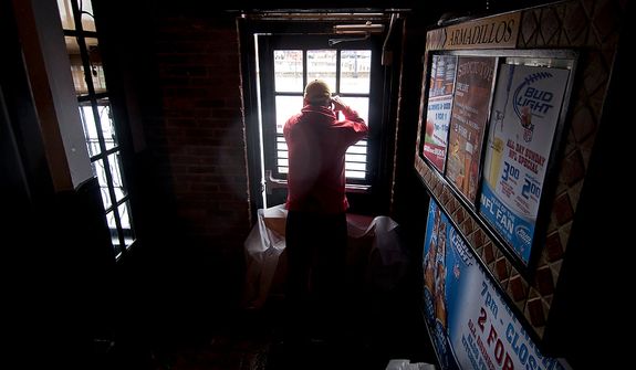 John O&#39;Leary, 41, from Annapolis, Md., looks out of Armadillos restaurant front door at Dock St. which had nearly a foot and half of water, Annapolis, Md., Tuesday, Oct. 30, 2012. The storm left early a foot and half of water along Dock St. but the stores are more worried about the tide which rises at 5:45pm and could bring another two feet of water. (Craig Bisacre/The Washington Times) 