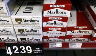 **FILE** Cartons of cigarettes sit on shelves at Discount Smoke Shop on Oct. 31, 2012, in Ballwin, Mo. (Associated Press)