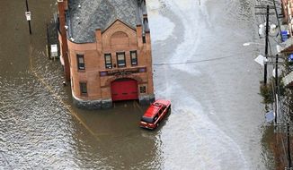 A firehouse is surrounded by floodwaters in the wake of superstorm Sandy on Tuesday, Oct. 30, 2012, in Hoboken, N.J. Sandy, the storm that made landfall Monday, caused multiple fatalities, halted mass transit and cut power to more than 6 million homes and businesses. (AP Photo/Mike Groll)