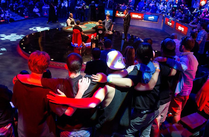 Supporters of Jesse Sylvia lock arms as they watch play in the 348th hand during the World Series of Poker Final Table event, Wednesday, Oct. 31, 2012, in Las Vegas. Sylvia won the hand and a four-bet pot. (AP Photo/Julie Jacobson)
