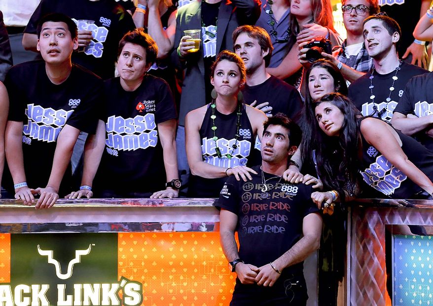 Jesse Sylvia, second from right, watches with his coach, Vanessa Solbst, second from left, as the dealer prepares to deliver the river card during the World Series of Poker Final Table event, Tuesday, Oct. 30, 2012, in Las Vegas. (AP Photo/Julie Jacobson)