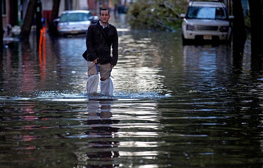 David Bagatelle, of Hoboken, N.J., walks from his residence on Park Avenue through high water in Hoboken, N.J., Wednesday, Oct. 31, 2012, in the wake of superstorm Sandy. Bagatelle's home is surrounded by water, but dry, where his wife and 7day-old baby are staying. (AP Photo/Craig Ruttle)