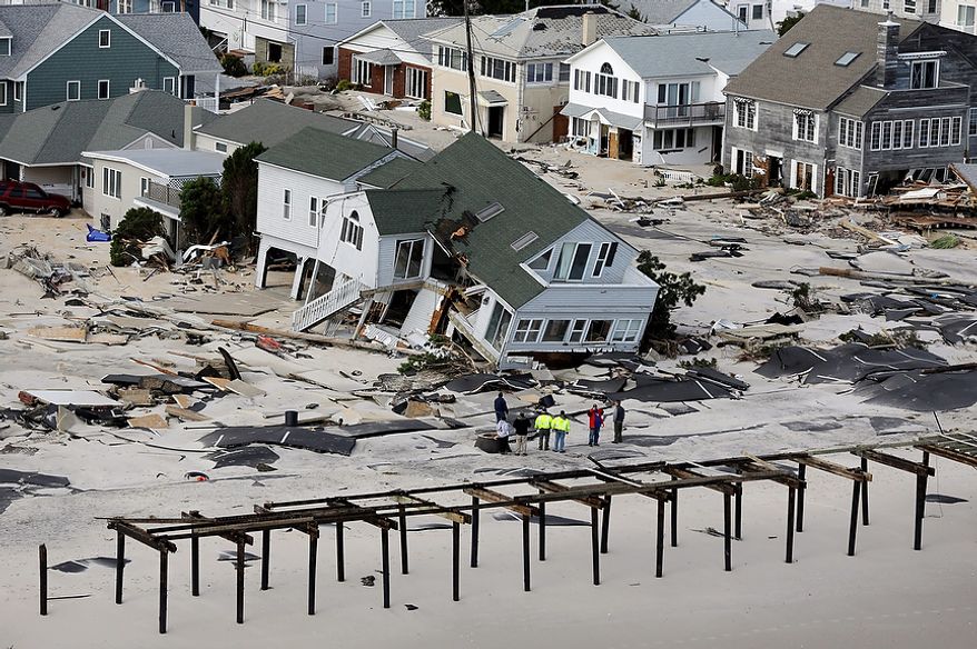 People survey the destruction left in the wake of Superstorm Sandy on Wednesday, Oct. 31, 2012, in Seaside Heights, N.J. (AP Photo/Mike Groll)
