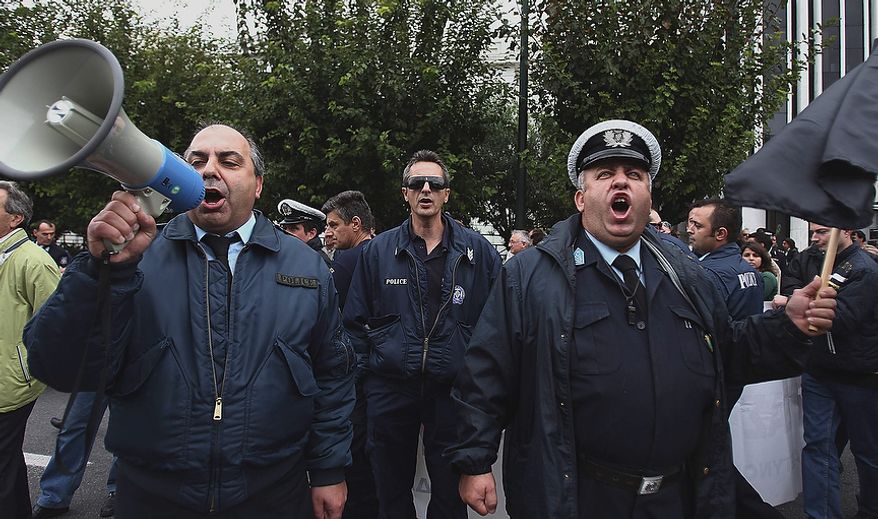 Police officers chant anti-government slogans during a protest in central Athens on Thursday, Nov. 1, 2012. More than a thousand protesting officers from the police, coast guard and fire department joined a rally in Athens to demonstrate against government cuts, in the latest protest ahead of a planned two-day general strike next week. (AP Photo/Thanassis Stavrakis)