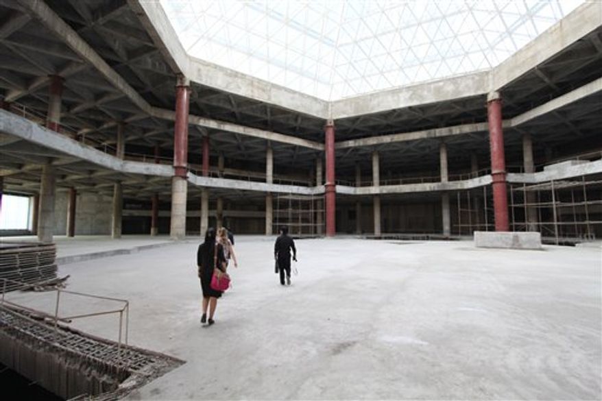 In this Sept. 23, 2012, photo released by Koryo Group, visitors tour the top floor of the 105-story Ryugyong Hotel in Pyongyang, North Korea. After years of standing unfinished, construction on the exterior of the massive hotel resumed three years ago, but the hotel has not yet opened to the public. This photo, taken by the Beijing-based Koryo Tours, shows that the interior remains unfinished. (AP Photo/Koryo Group)