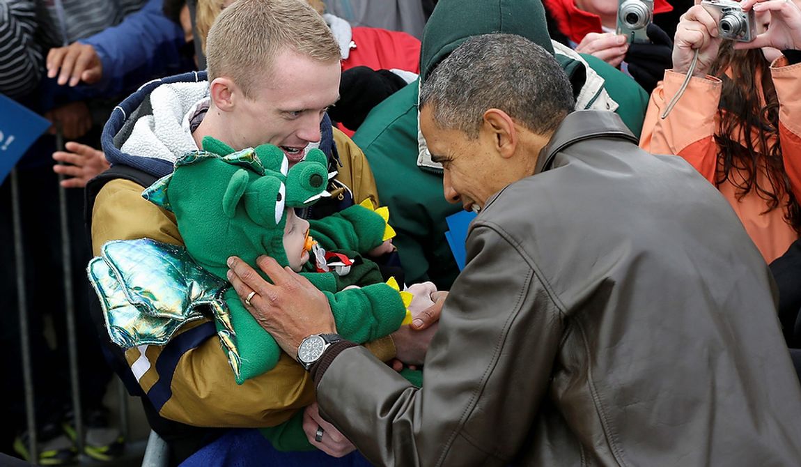 President Obama stops to greet a small child in a dragon costume during a campaign event at Austin Straubel International Airport in Green Bay, Wis., on Thursday, Nov. 1, 2012. Mr. Obama resumed his presidential campaign with travel to the key battleground states of Wisconsin, Colorado, Nevada and Ohio today. (AP Photo/Pablo Martinez Monsivais)
