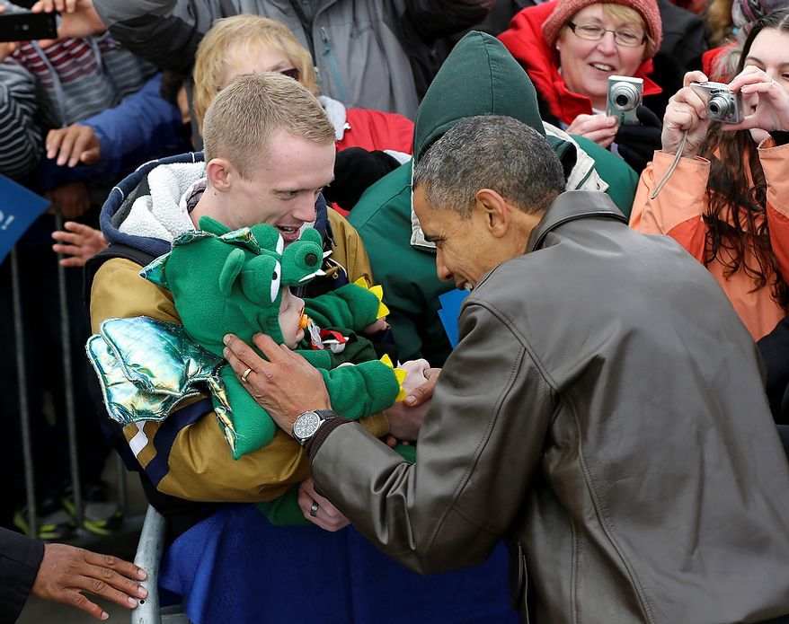 President Obama stops to greet a small child in a dragon costume during a campaign event at Austin Straubel International Airport in Green Bay, Wis., on Thursday, Nov. 1, 2012. Mr. Obama resumed his presidential campaign with travel to the key battleground states of Wisconsin, Colorado, Nevada and Ohio today. (AP Photo/Pablo Martinez Monsivais)