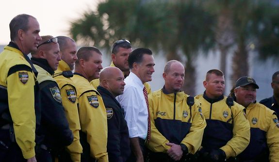Republican presidential candidate, former Massachusetts Gov. Mitt Romney poses for a photo with law enforcement members which escorted his motorcade before boarding his  campaign plane in Jacksonville, Fla., Thursday, Nov. 1, 2012, enroute to campaign stops in Virginia. (AP Photo/Charles Dharapak)