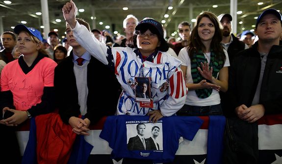 Supporter Annie Lin, from Salem, Va., center, wearing plastic Romney lawn signs, cheers Republican presidential candidate, former Massachusetts Gov. Mitt Romney while he speaks at a campaign event at Integrity Windows in Roanoke, Va., Thursday, Nov. 1, 2012. (AP Photo/Charles Dharapak)