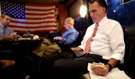 Republican presidential candidate and former Massachusetts Gov. Mitt Romney holds a peanut butter and honey sandwich he made for himself as he looks over his iPad while seated in the back of his campaign bus with chief strategist Stuart Stevens, center, and senior adviser Kevin Madden as they leave a campaign event at Meadow Event Park, in Dowell, Va., for another rally in Virginia Beach, Va., Thursday, Nov. 1, 2012. (AP Photo/Charles Dharapak)