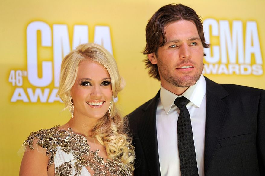 Carrie Underwood, left, and her husband Mike Fisher arrive at the 46th Annual Country Music Awards at the Bridgestone Arena on Thursday, Nov. 1, 2012, in Nashville, Tenn. (Photo by Chris Pizzello/Invision/AP)