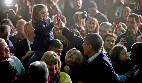 President Barack Obama high-five a young girls while meeting with supporters after speaking at a campaign event at Franklin County Fairgrounds in Hilliard, Ohio, Friday, Nov. 2, 2012. (AP Photo/Pablo Martinez Monsivais)