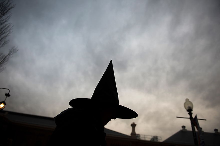 Michelle Carroll, of Washington, D.C., offers glow sticks and tooth brushes to kids, as residents arrive for Halloween festivities at Eastern Market in Washington, D.C., Wednesday, Oct. 31, 2012. (Rod Lamkey Jr./The Washington Times)