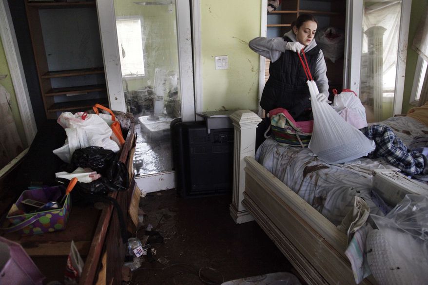 Brooke Clarkin tries to salvage some personal items from her mother's home in Staten Island, New York, Thursday, Nov. 1, 2012. Her mother's home was not only flooded to the ceiling, but was swept off its foundation and was carried to the other side of the street. (AP Photo/Seth Wenig)