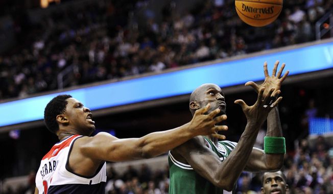 Washington Wizards forward Kevin Seraphin, left, of France, battles for the ball against Boston Celtics forward Kevin Garnett, right, during the second half of an NBA basketball game, Saturday, Nov. 3, 2012, in Washington. The Celtics won 89-86. (AP Photo/Nick Wass)
