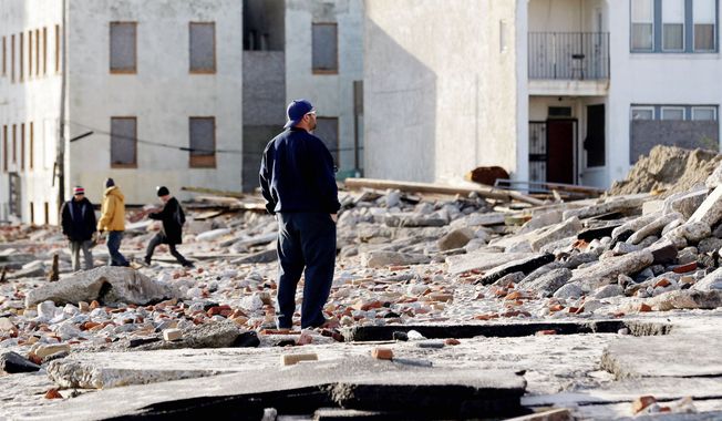 Raymond Simpson Jr., with Atlantic City’s Department of Public Works, examines the damage of Superstorm Sandy, which caused multiple fatalities, halted mass transit and cut power to more than 6 million homes and businesses. (Associated Press)