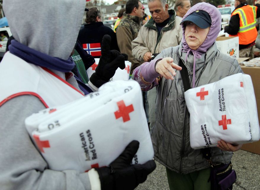 Galina Quacinella (right) gets some blankets for herself and her husband at a Red Cross aid station on Staten Island. Overnight temperatures are sinking into the 30s. The city has opened warming centers in senior centers and set up food distribution sites. (Associated Press)