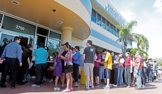Voters wait to pick up their absentee ballots in Doral, Fla., on Sunday. Christina White, deputy supervisor with Miami-Dade County, said the county decided to accept absentee ballots for four hours on Sunday at its main office. An estimated 25 million voters are expected to vote early this year nationwide, the most in U.S. history. (Associated Press)